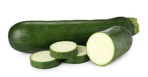 Photo of Whole and cut fresh zucchinis isolated on white
