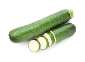 Photo of Whole and cut fresh zucchinis isolated on white, top view