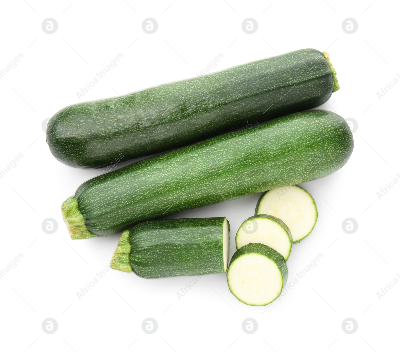 Whole and cut fresh zucchinis isolated on white, top view Photo of Whole and cut fresh zucchinis isolated on white, top view