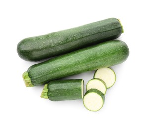 Photo of Whole and cut fresh zucchinis isolated on white, top view