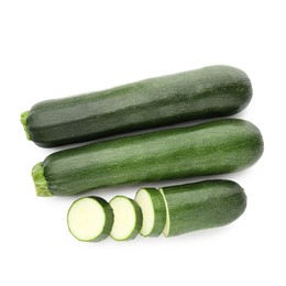 Photo of Whole and cut fresh zucchinis isolated on white, top view