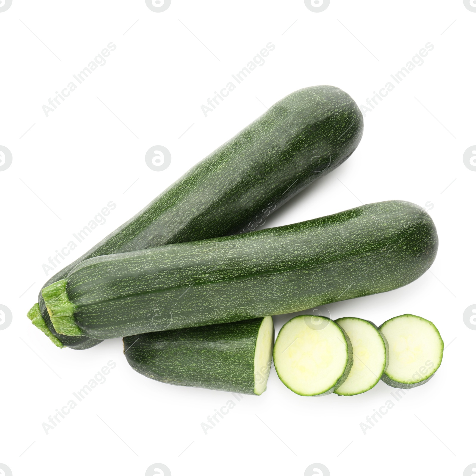Whole and cut fresh zucchinis isolated on white, top view Photo of Whole and cut fresh zucchinis isolated on white, top view