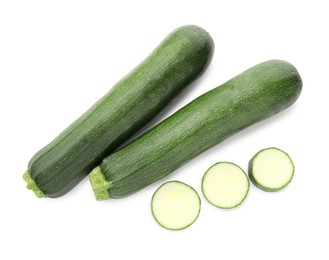 Photo of Whole and cut fresh zucchinis isolated on white, top view