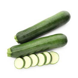 Photo of Whole and cut fresh zucchinis isolated on white, top view
