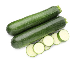 Photo of Whole and cut fresh zucchinis isolated on white, top view