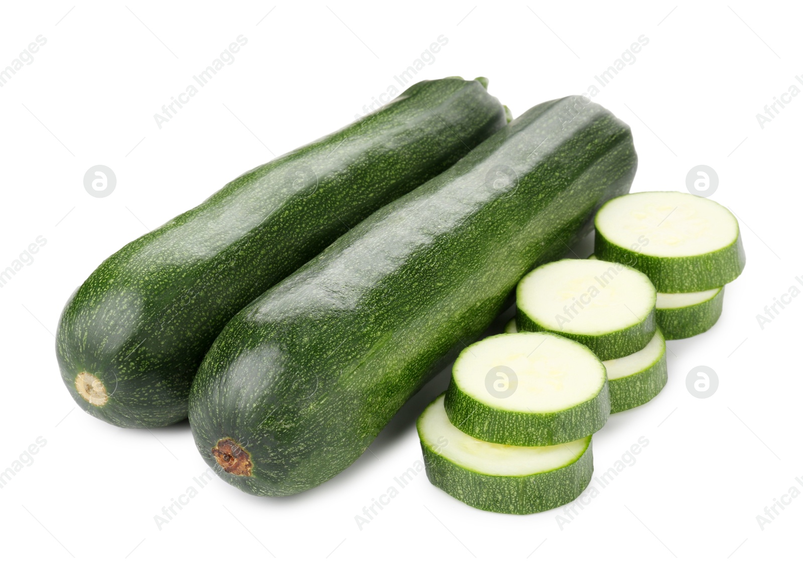 Whole and cut fresh zucchinis isolated on white Photo of Whole and cut fresh zucchinis isolated on white