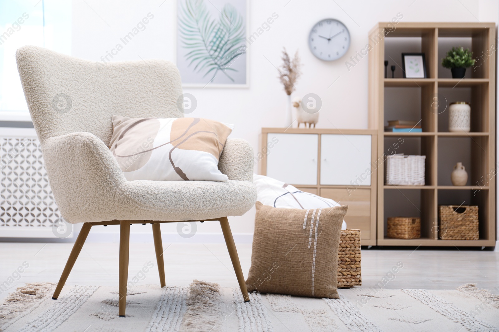 Photo of White armchair with pillow indoors. Interior design