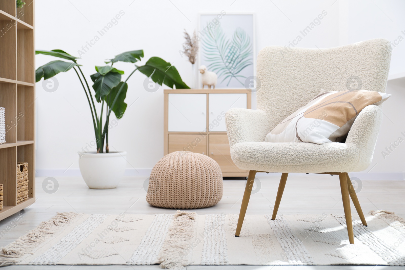 Photo of White armchair with pillow indoors. Interior design