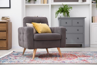 Photo of Grey armchair with pillows indoors. Interior design