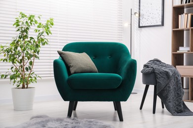 Photo of Stylish armchair with pillow indoors. Interior design
