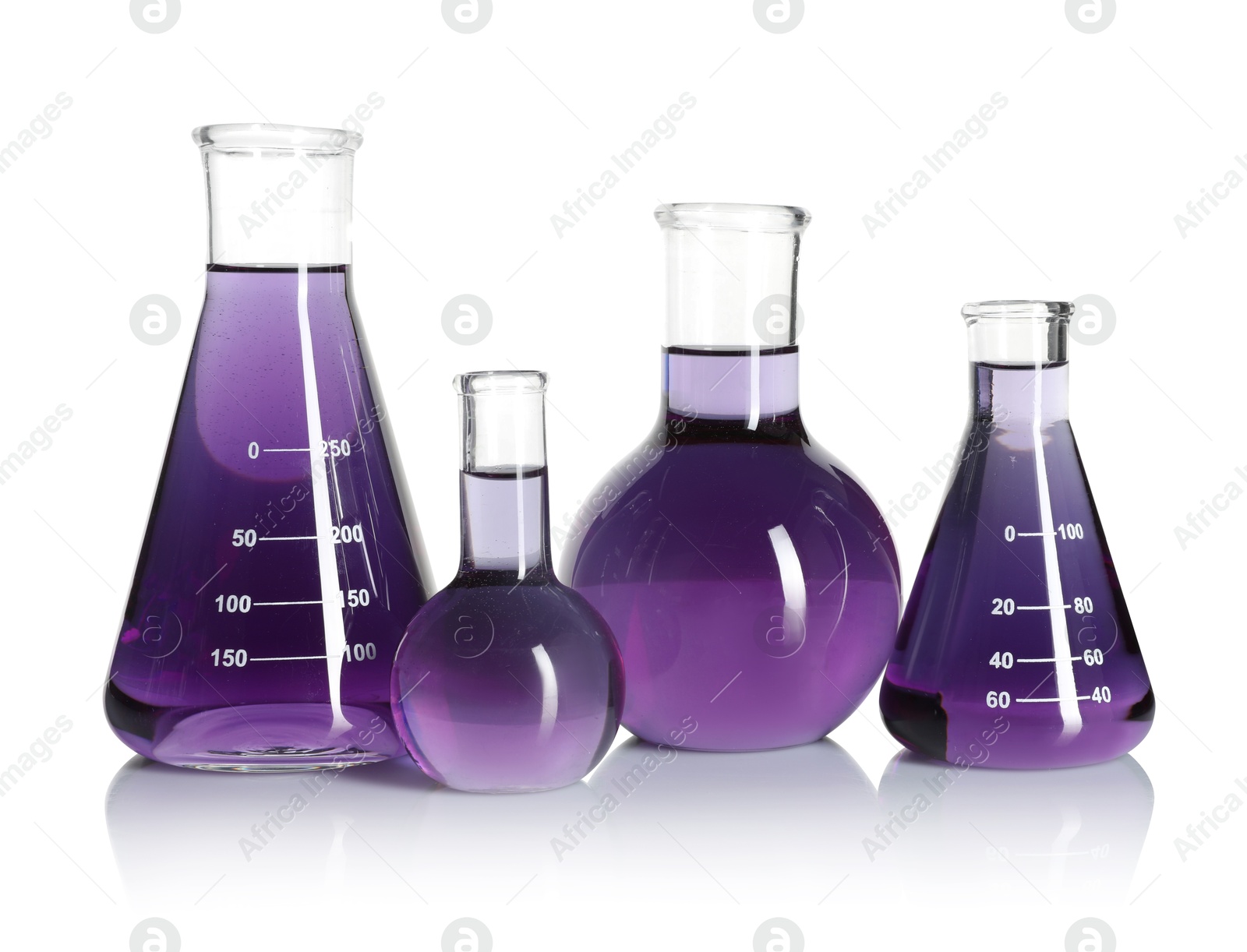 Laboratory glassware with violet liquid isolated on white Photo of Laboratory glassware with violet liquid isolated on white