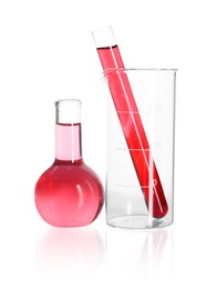 Photo of Laboratory glassware with pink liquid isolated on white