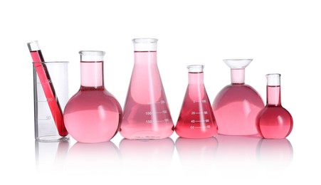 Photo of Laboratory glassware with pink liquid isolated on white