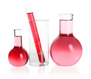 Photo of Laboratory glassware with pink liquid isolated on white