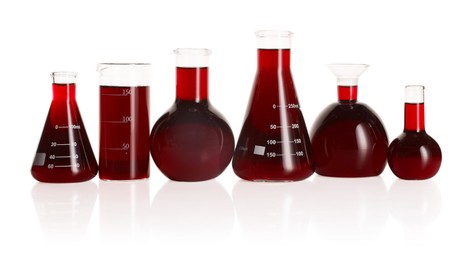 Photo of Laboratory glassware with red liquid isolated on white
