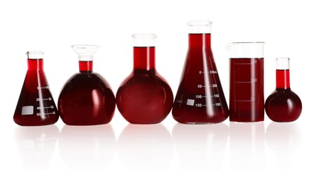 Photo of Laboratory glassware with red liquid isolated on white