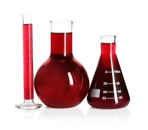 Photo of Laboratory glassware with red liquid isolated on white