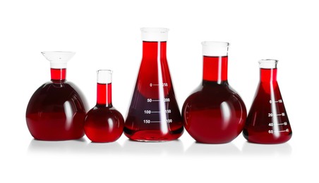 Photo of Laboratory glassware with red liquid isolated on white