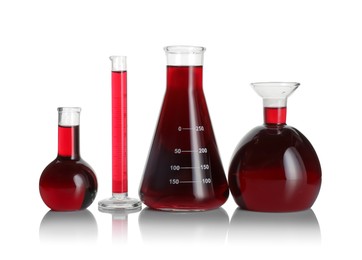 Photo of Laboratory glassware with red liquid isolated on white