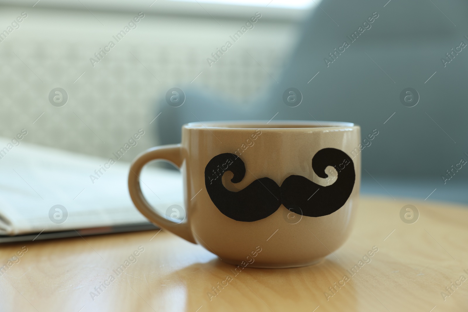 Happy Father's Day. Cup with mustache on wooden table indoors, closeup Photo of Happy Father's Day. Cup with mustache on wooden table indoors, closeup