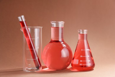 Photo of Laboratory glassware with red liquid on color background