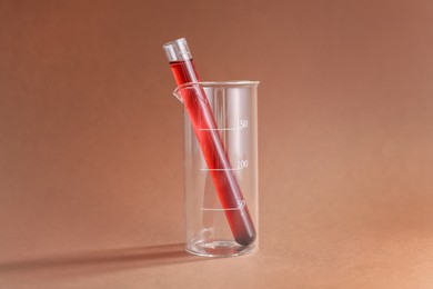 Photo of Laboratory glassware with red liquid on color background