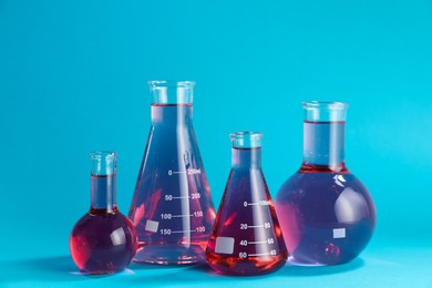 Photo of Laboratory glassware with color liquid on light blue background