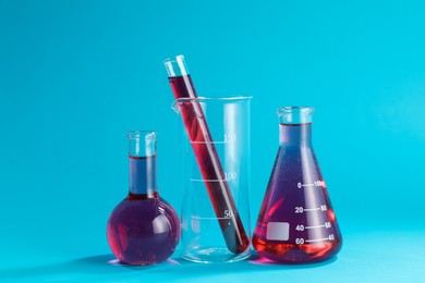 Photo of Laboratory glassware with color liquid on light blue background