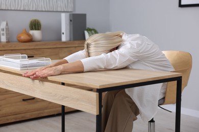 Photo of Mature woman stretching at table in office