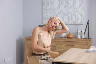 Photo of Mature woman stretching at table in office