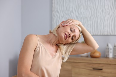 Photo of Beautiful mature woman stretching at workplace. Healthy leisure