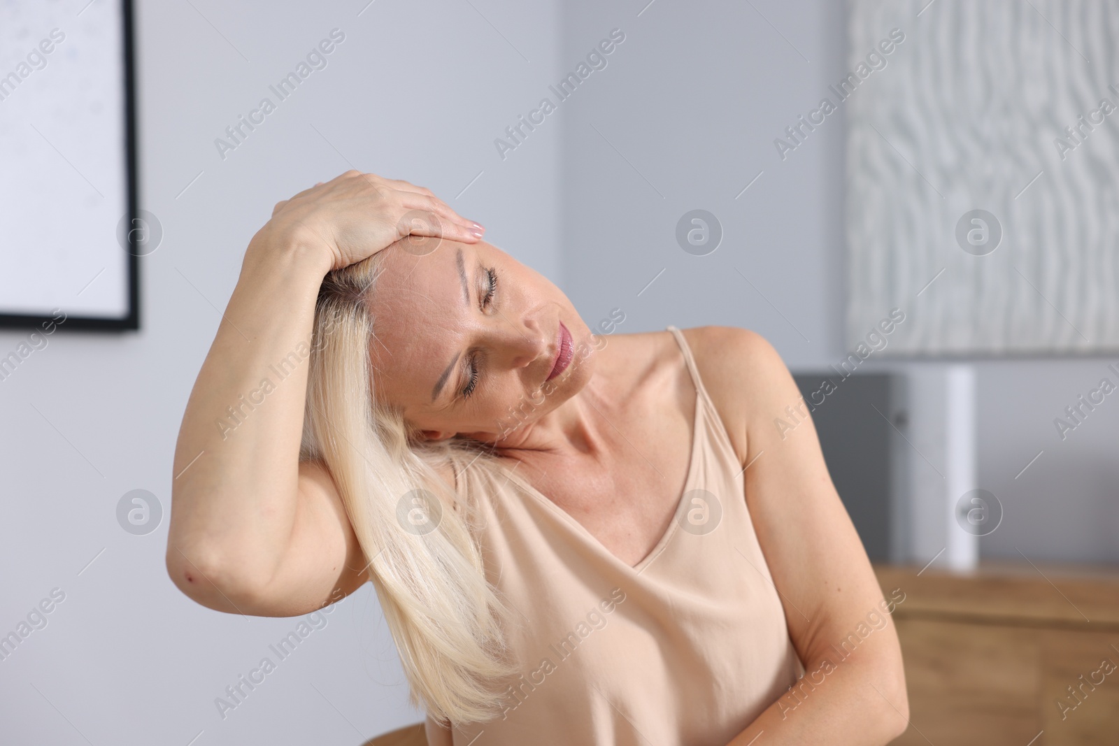 Photo of Beautiful mature woman stretching at workplace. Healthy leisure