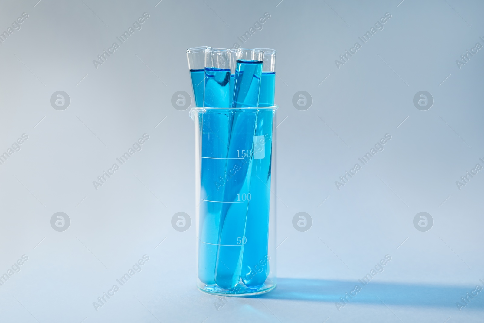 Test tubes with blue liquid on light background Photo of Test tubes with blue liquid on light background