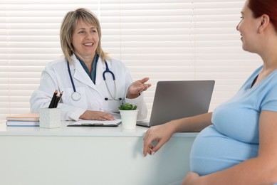 Photo of Pregnant woman having appointment with doctor in clinic