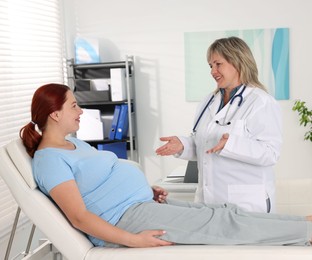 Photo of Pregnant woman having appointment with doctor in clinic