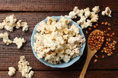 Photo of Tasty popcorn and corn kernels on wooden table, flat lay
