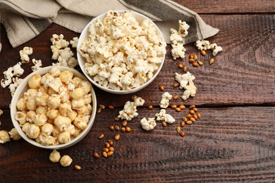 Photo of Tasty popcorn and corn kernels on wooden table, flat lay. Space for text