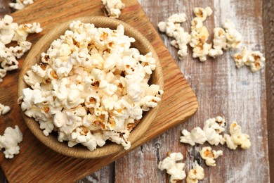 Photo of Tasty popcorn on wooden table, flat lay