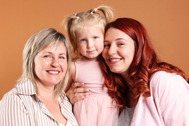 Photo of Grandmother, her daughter and granddaughter on brown background