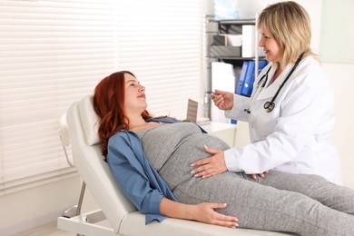 Photo of Pregnant woman having appointment with doctor in clinic
