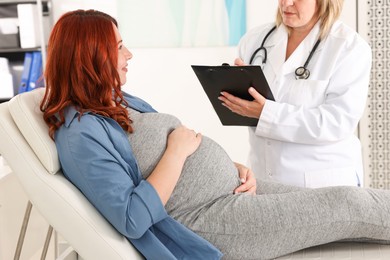 Photo of Pregnant woman having appointment with doctor in clinic