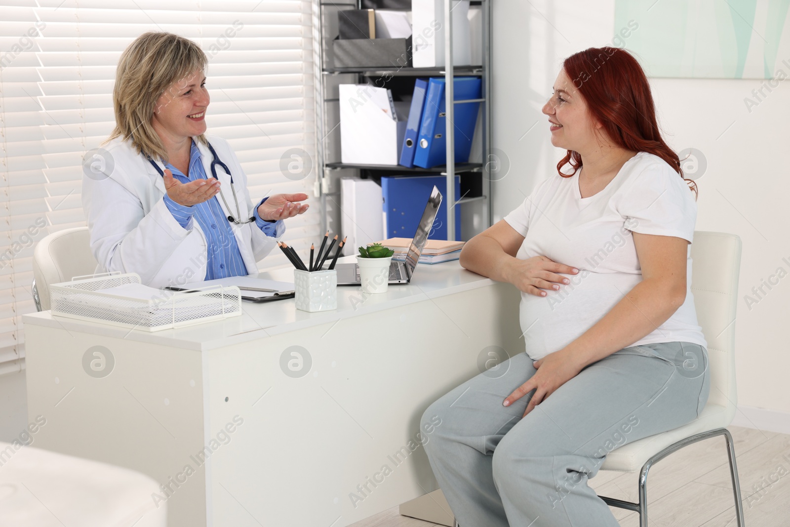 Pregnant woman having appointment with doctor in clinic Photo of Pregnant woman having appointment with doctor in clinic