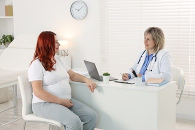 Photo of Pregnant woman having appointment with doctor in clinic