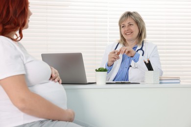 Photo of Pregnant woman having appointment with doctor in clinic