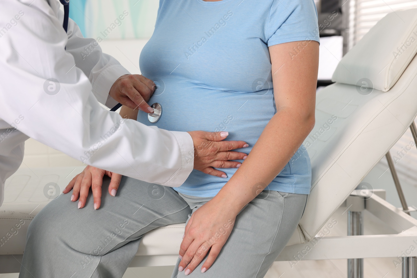 Pregnancy checkup. Doctor with stethoscope listening baby's heartbeat in patient's tummy indoors, closeup Photo of Pregnancy checkup. Doctor with stethoscope listening baby's heartbeat in patient's tummy indoors, closeup