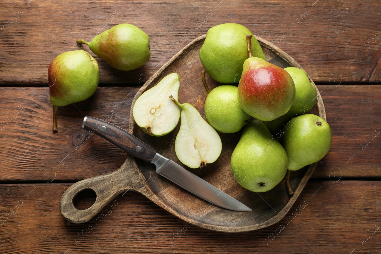 Photo of Fresh ripe pears and knife on wooden table, top view