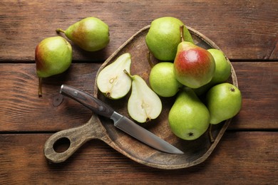 Photo of Fresh ripe pears and knife on wooden table, top view