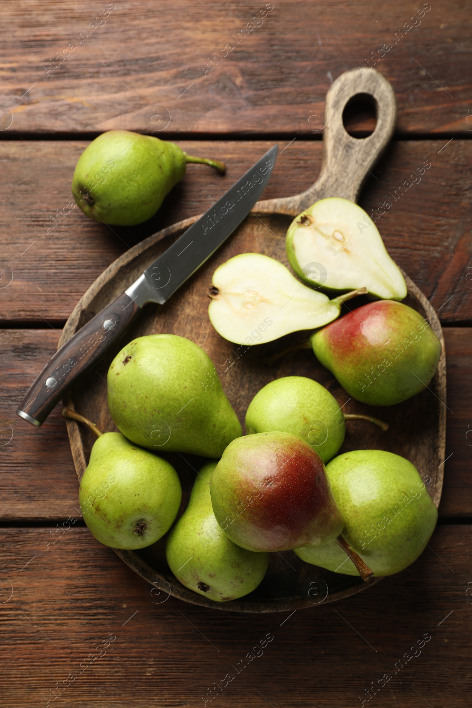 Photo of Fresh ripe pears and knife on wooden table, top view