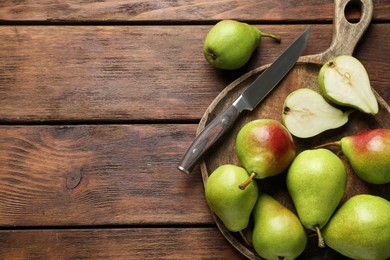 Photo of Fresh ripe pears and knife on wooden table, top view. Space for text