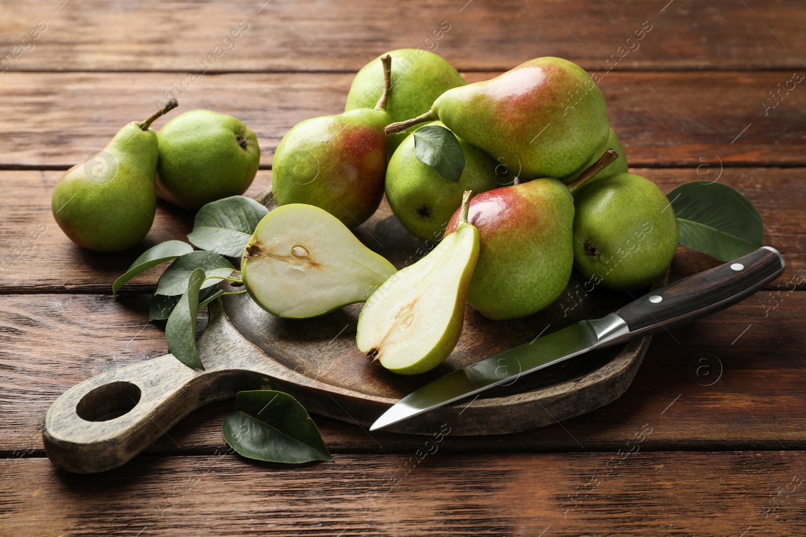 Photo of Fresh ripe pears and knife on wooden table, closeup
